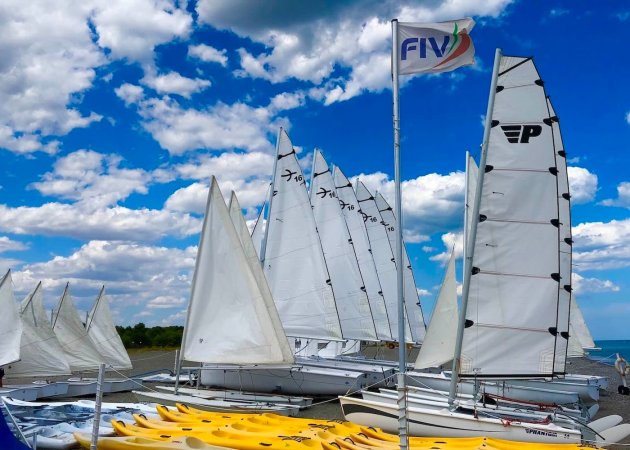 Barche a vela bianche con un cielo nuvoloso.