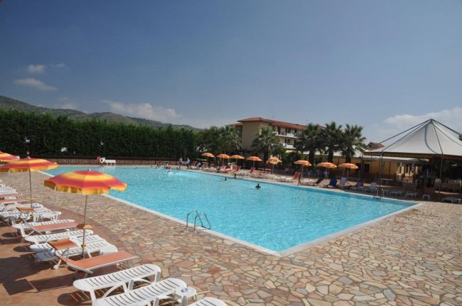 Piscina all'aperto con lettini e ombrelloni colorati.