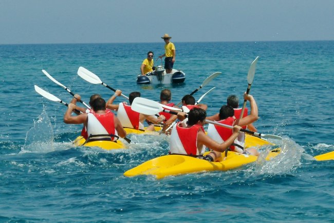Persone in canoa che pagaiamo in mare.
