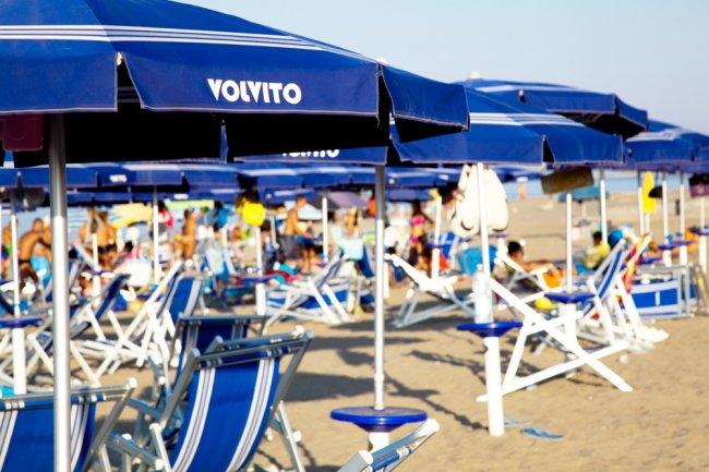Ombrelloni blu su una spiaggia affollata.